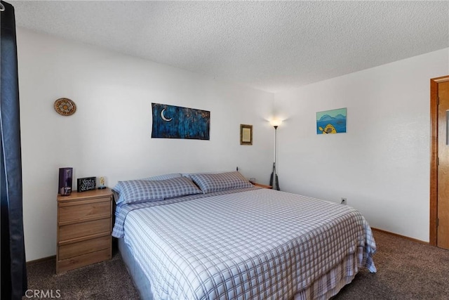 bedroom with dark carpet and a textured ceiling