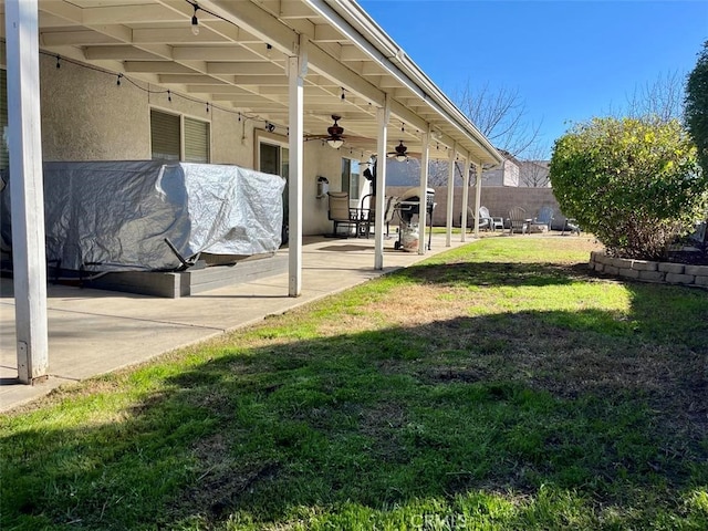 view of yard with a ceiling fan, a patio area, and a fenced backyard