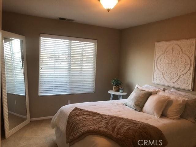 carpeted bedroom featuring visible vents and baseboards