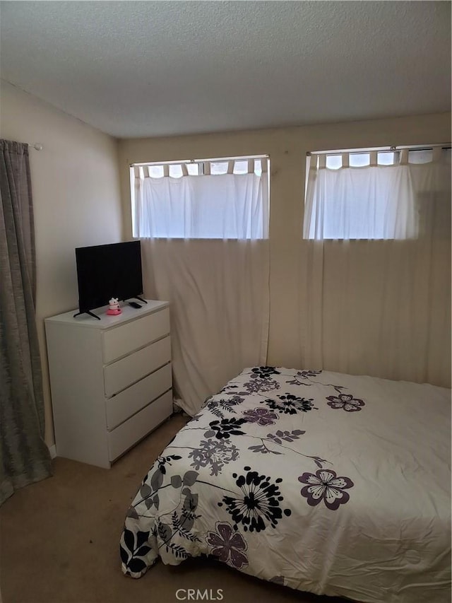 carpeted bedroom featuring a textured ceiling