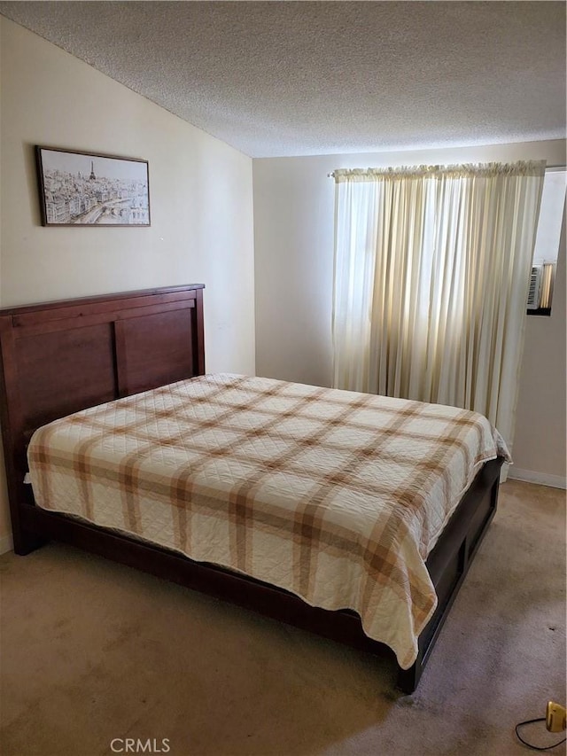carpeted bedroom featuring a textured ceiling and lofted ceiling