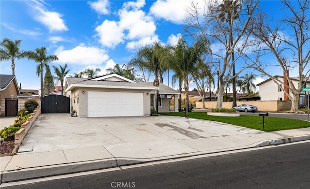 single story home with concrete driveway, a residential view, an attached garage, a gate, and stucco siding