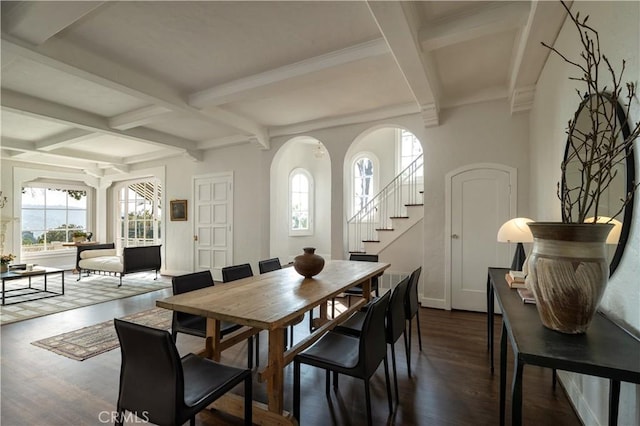 dining area with arched walkways, dark wood-style flooring, beam ceiling, stairway, and coffered ceiling