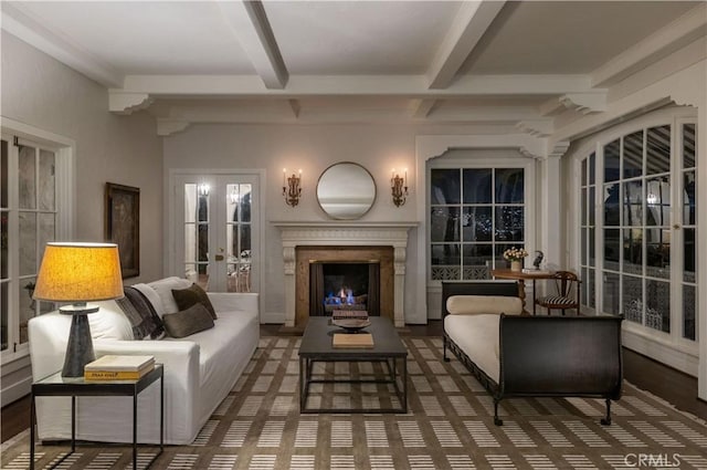 living area with french doors, a premium fireplace, and beamed ceiling