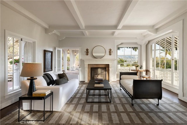 living area featuring beam ceiling, a fireplace, and baseboards