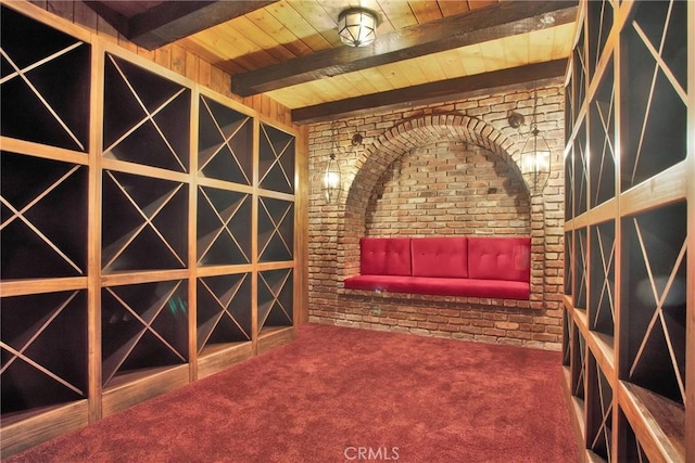 wine area featuring wood ceiling, carpet, brick wall, and beamed ceiling