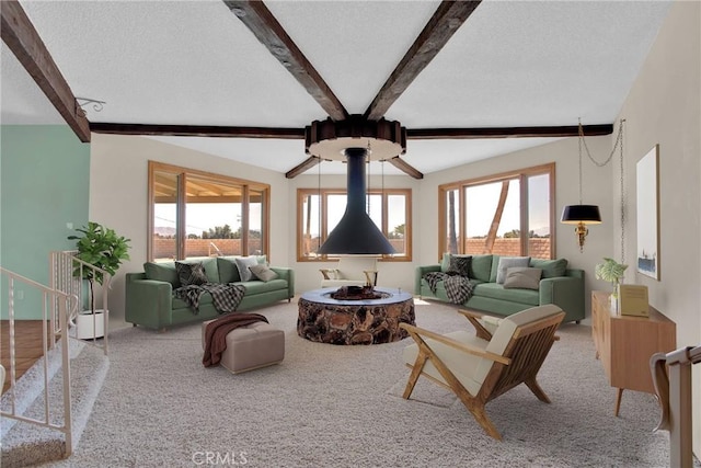 living room with a textured ceiling, beam ceiling, and carpet flooring