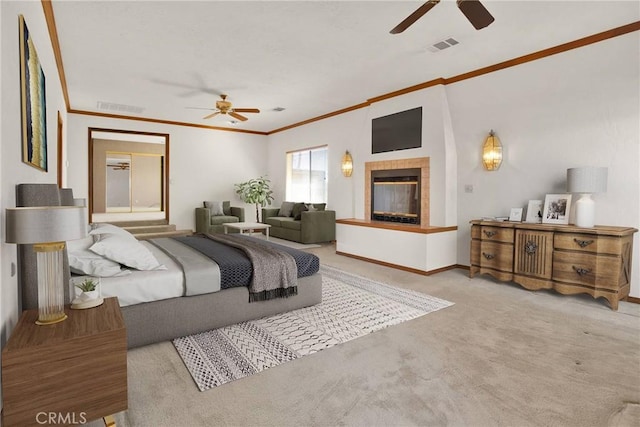 bedroom featuring light carpet, visible vents, a tiled fireplace, and ornamental molding