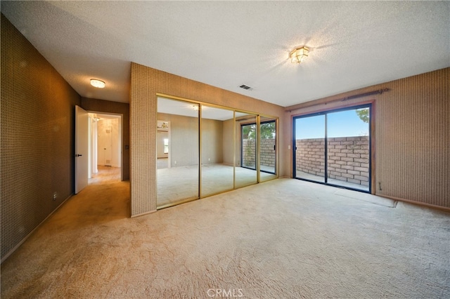 19459 Shasta Rd, Apple Valley, CA 92307 - unfurnished bedroom with access to exterior, carpet, a textured ceiling, and a closet