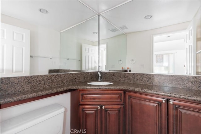 bathroom with toilet, recessed lighting, and vanity