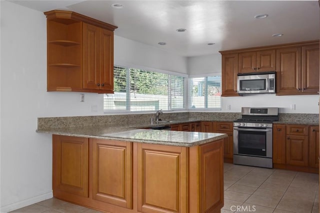 kitchen with brown cabinetry, appliances with stainless steel finishes, a peninsula, open shelves, and light tile patterned flooring