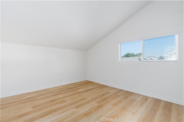 additional living space featuring lofted ceiling, light wood-style flooring, and baseboards