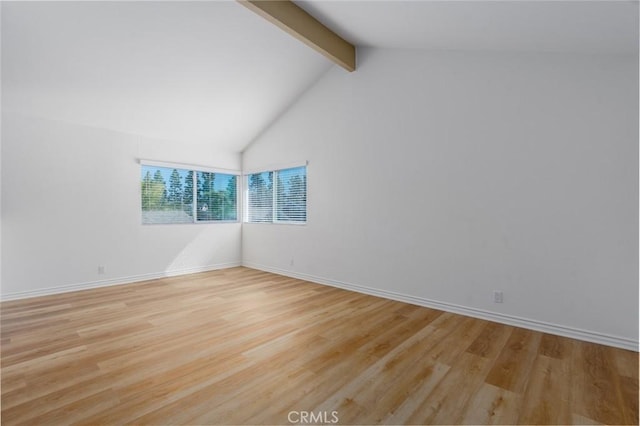 unfurnished room featuring high vaulted ceiling, light wood-style flooring, baseboards, and beam ceiling