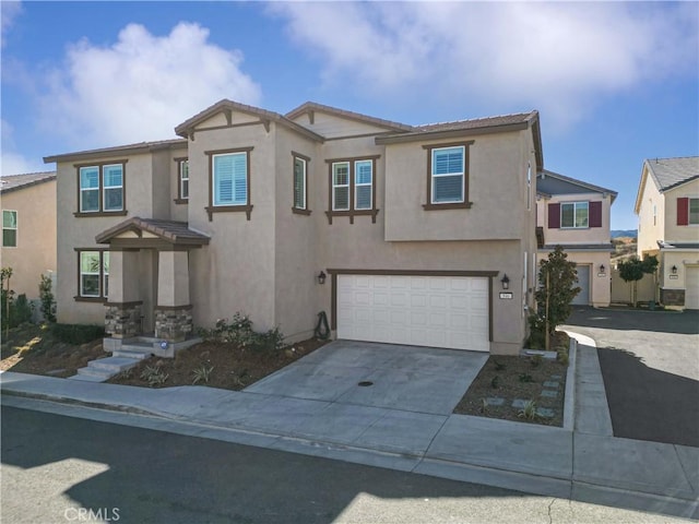 view of front of property featuring driveway, an attached garage, and stucco siding