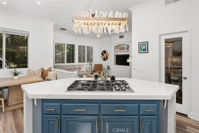 kitchen featuring blue cabinets, stainless steel gas cooktop, light countertops, and crown molding