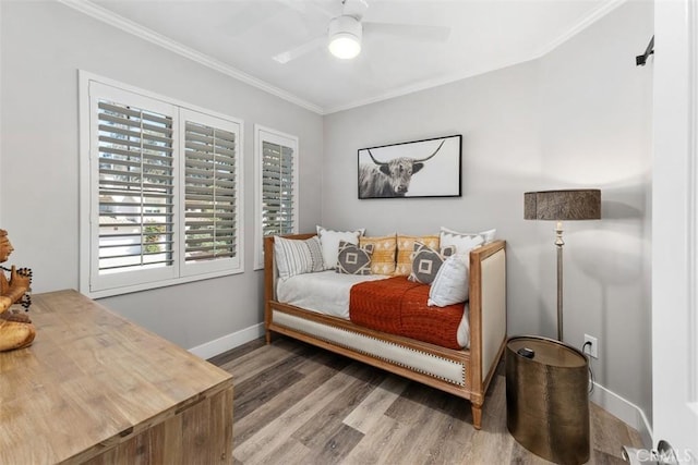 bedroom with baseboards, ceiling fan, wood finished floors, and crown molding