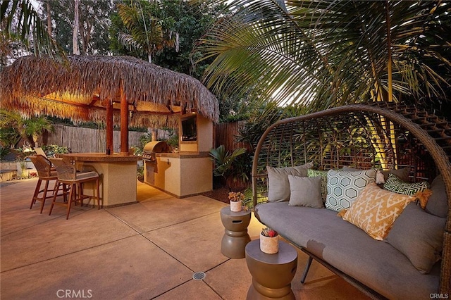 view of patio / terrace with outdoor dry bar, grilling area, an outdoor kitchen, and a fenced backyard