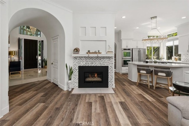 living area with recessed lighting, dark wood finished floors, and crown molding