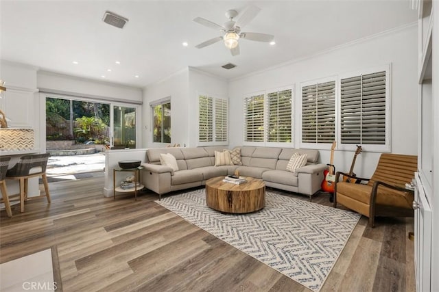 living area with light wood finished floors, crown molding, and recessed lighting