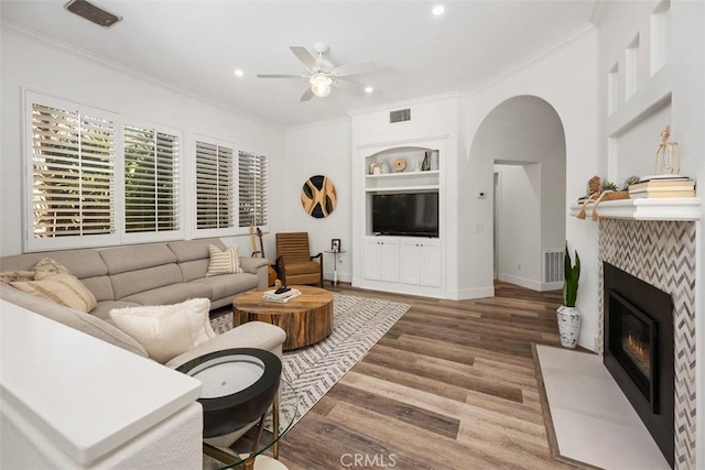 living room featuring ornamental molding, visible vents, and wood finished floors