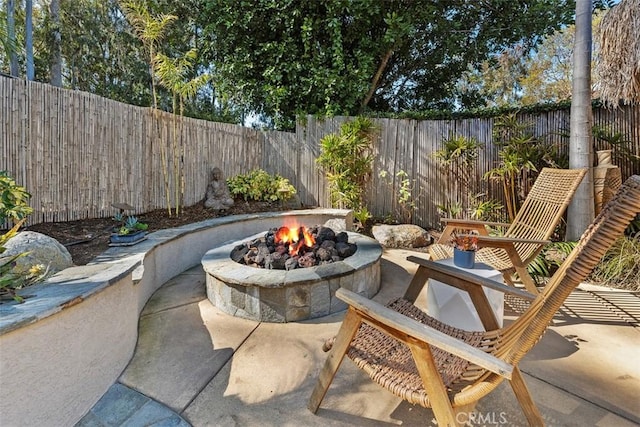 view of patio featuring a fenced backyard and a fire pit