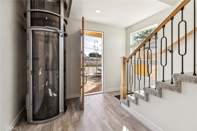 foyer featuring light wood-style floors, stairs, and baseboards