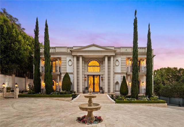 neoclassical home featuring fence