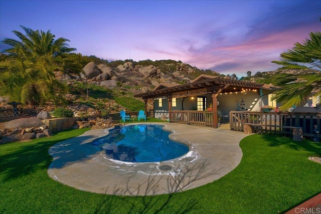 outdoor pool with a patio area, a lawn, fence, and a pergola