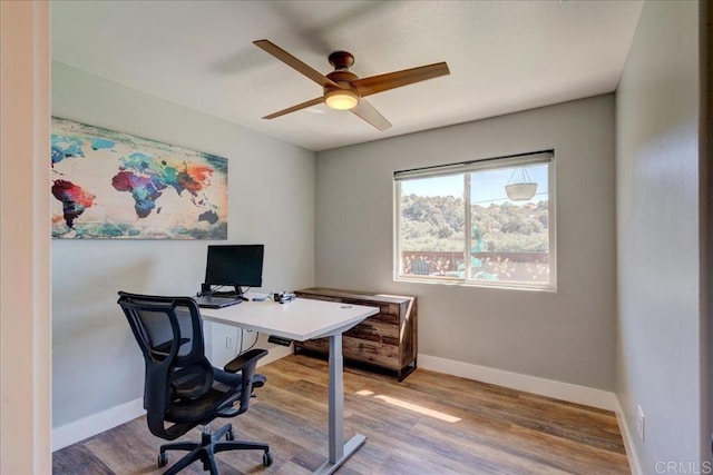 office space featuring wood finished floors, a ceiling fan, and baseboards
