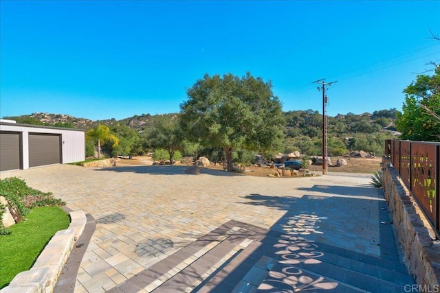 view of patio / terrace featuring a detached garage and fence