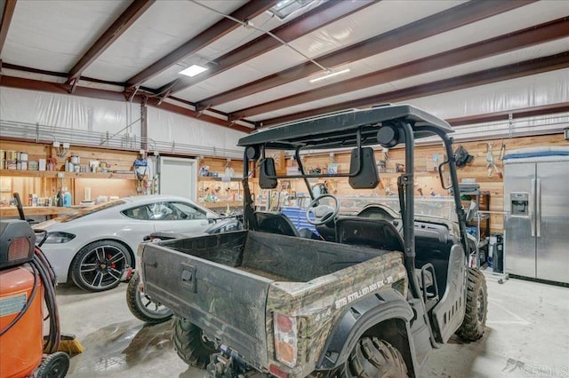 garage featuring stainless steel refrigerator with ice dispenser