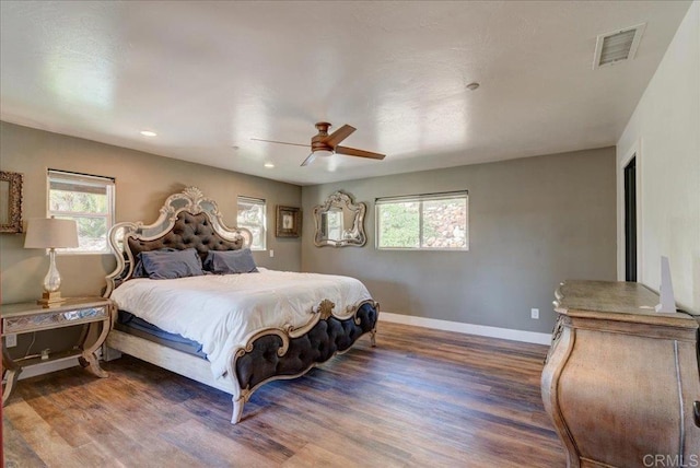 bedroom featuring visible vents, wood finished floors, and multiple windows