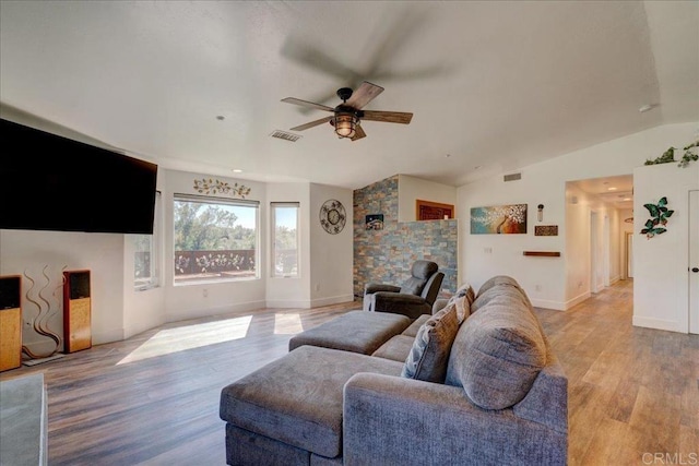 living room with light wood finished floors, a ceiling fan, visible vents, and lofted ceiling