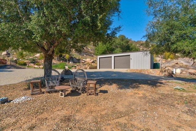 view of yard with an outdoor structure and a detached garage