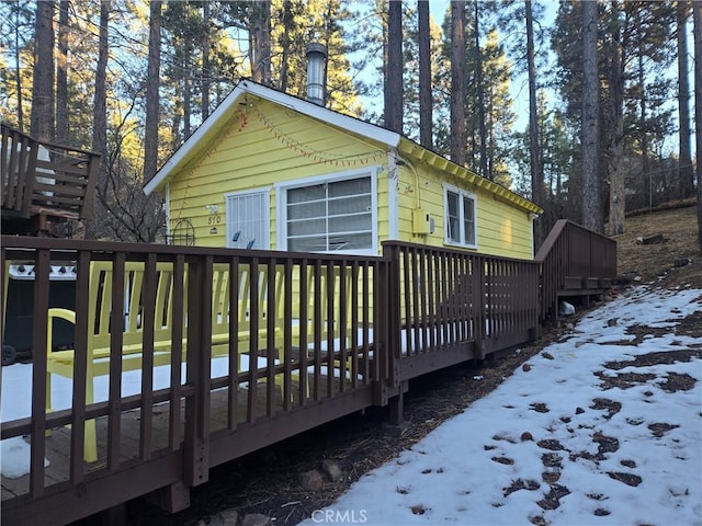 view of snowy exterior with a deck