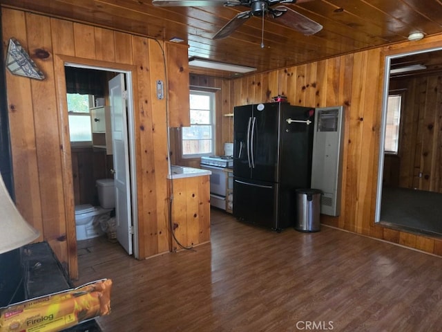 kitchen with light countertops, black fridge, brown cabinets, and white range with gas cooktop