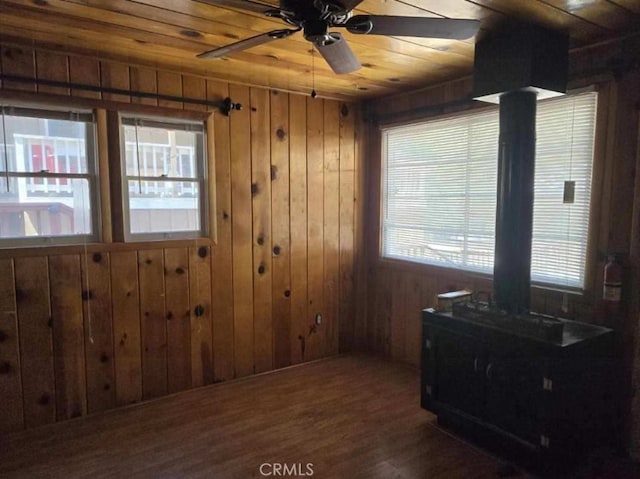 interior space featuring ceiling fan, wood finished floors, wood ceiling, and wooden walls