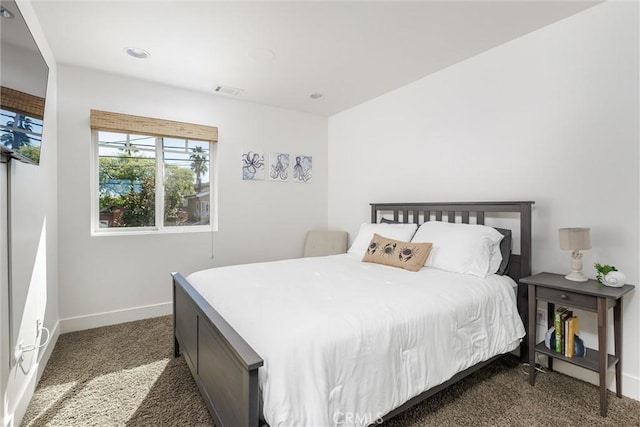 bedroom with baseboards, visible vents, and dark carpet