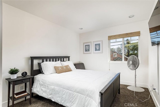 bedroom featuring dark carpet and baseboards