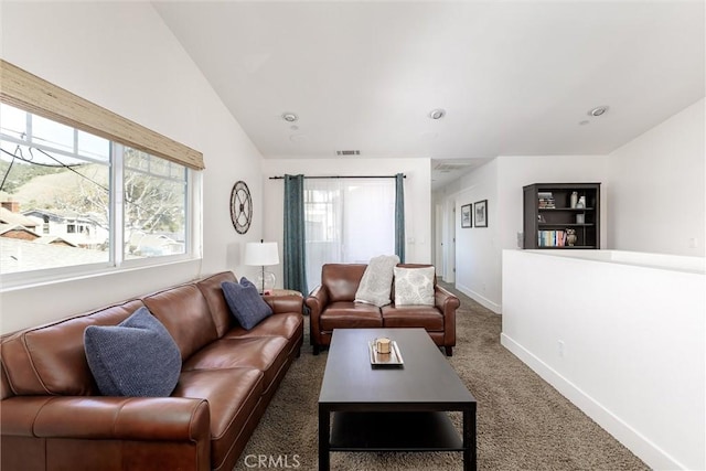 living room featuring lofted ceiling, visible vents, dark carpet, and baseboards