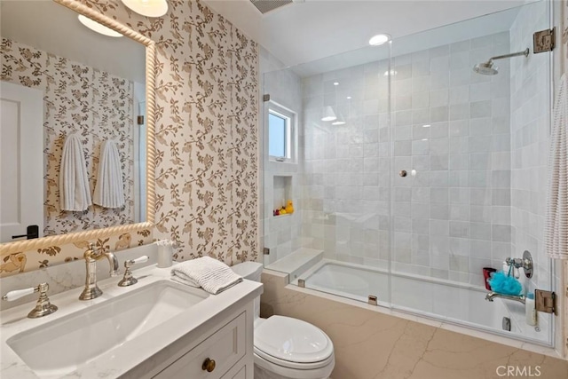 full bath featuring toilet, visible vents, vanity, combined bath / shower with glass door, and wallpapered walls