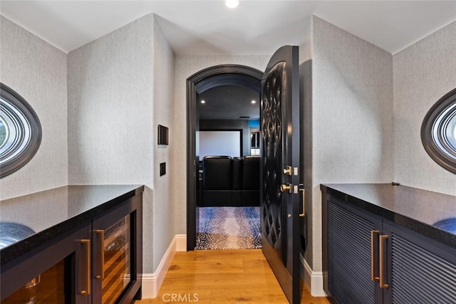 interior space with wine cooler, light wood-style flooring, and baseboards