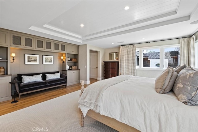 bedroom featuring light wood-style floors, a tray ceiling, and recessed lighting