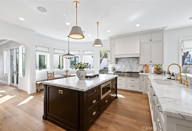 kitchen with appliances with stainless steel finishes, a sink, dark brown cabinetry, and white cabinets