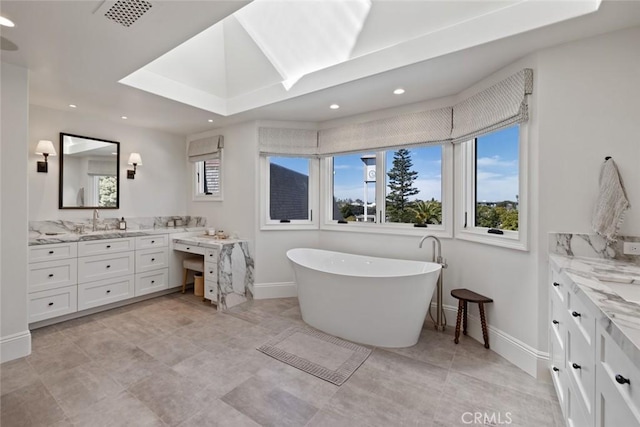 bathroom featuring a freestanding tub, recessed lighting, visible vents, vanity, and baseboards