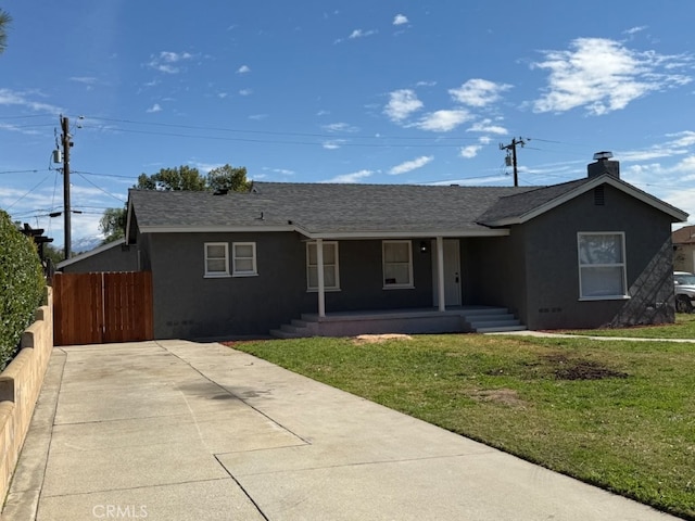 ranch-style house with a front lawn, a shingled roof, fence, and stucco siding