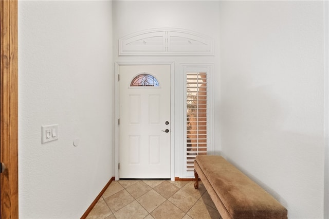 entryway with light tile patterned flooring and baseboards