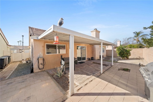 rear view of house with a patio, a fenced backyard, and stucco siding