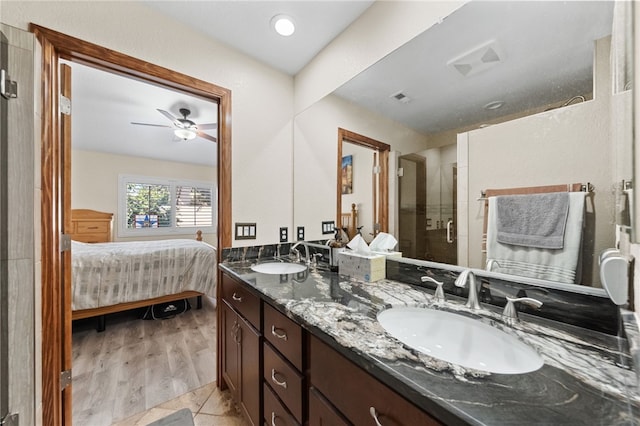 bathroom with double vanity, a stall shower, a sink, and ensuite bathroom