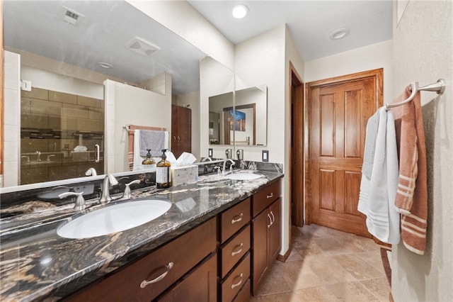 full bathroom featuring double vanity, a sink, and tiled shower